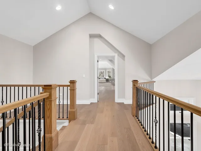 a view of a hallway with wooden floor and closet