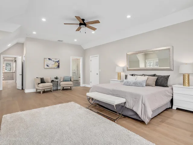 a spacious bedroom with a bed and a chandelier