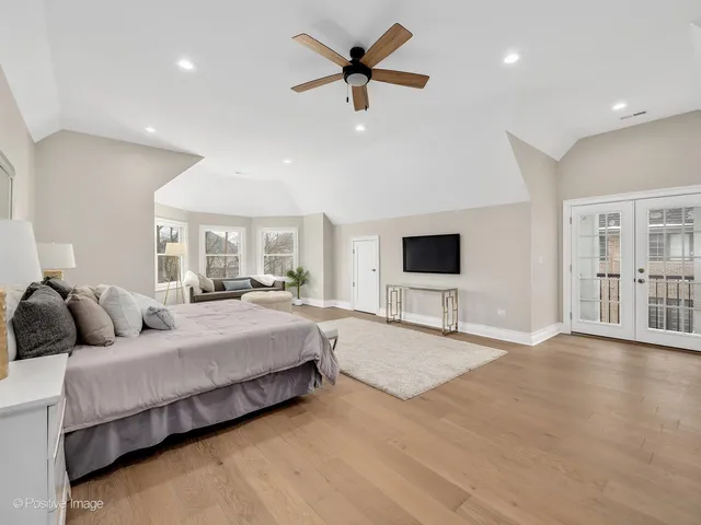 a spacious bedroom with a bed window and a flat screen tv