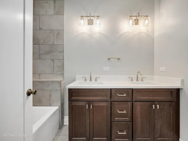 a bathroom with a sink double vanity mirror and bathtub