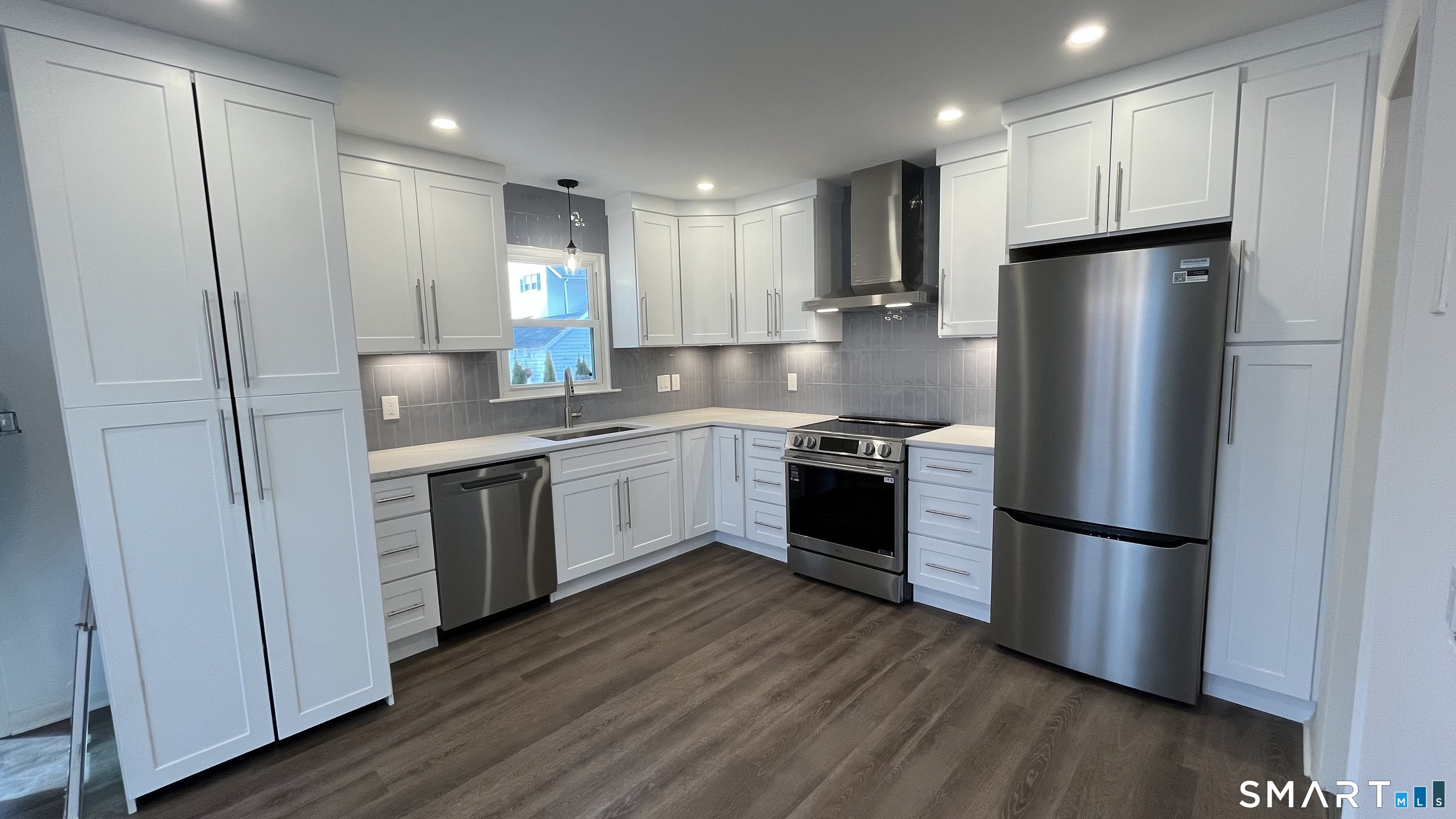 a kitchen with a refrigerator sink and cabinets