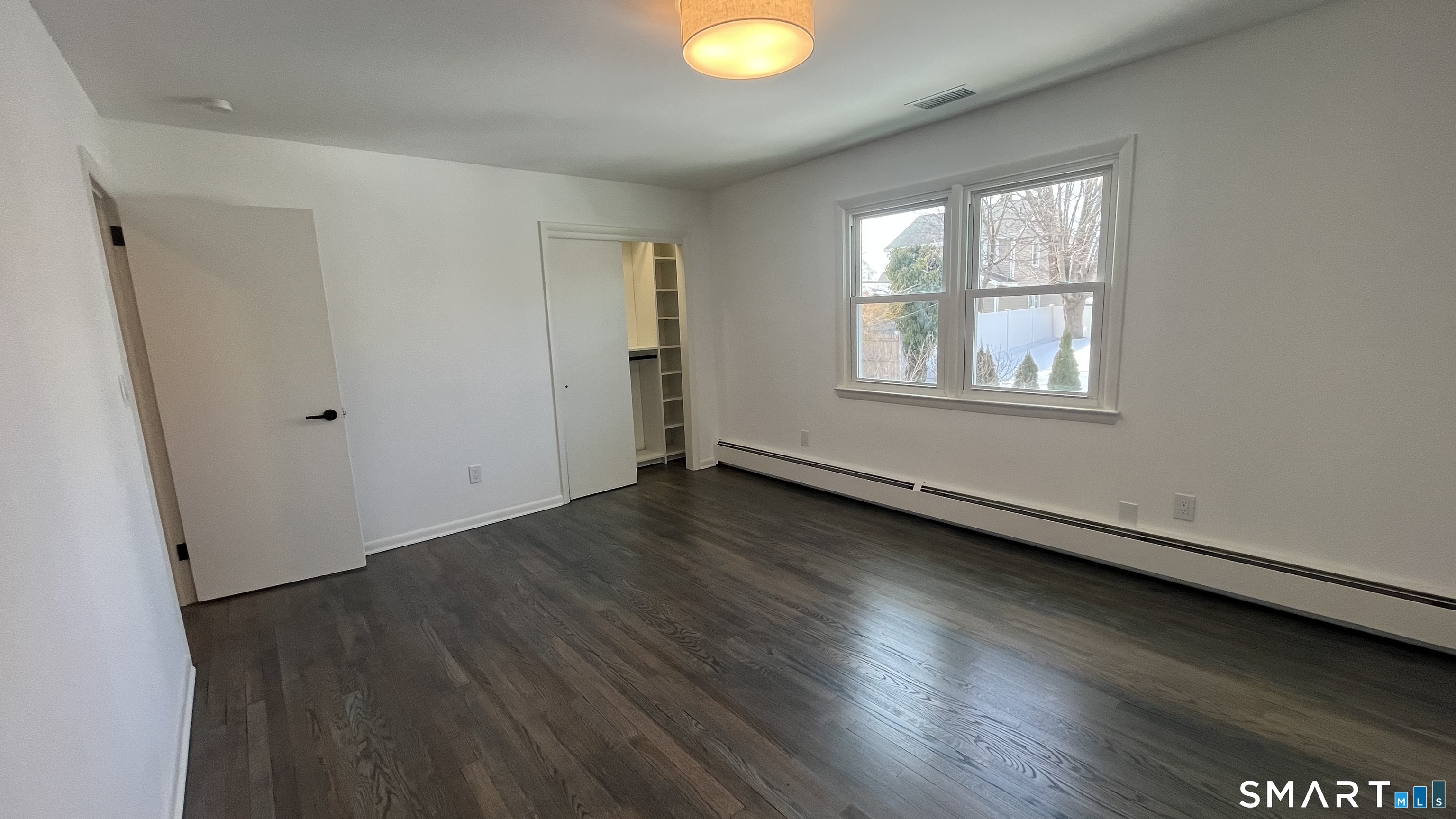 34 Keith Street, Unit 2 Stamford, CT 06902 - Photo 11 of 15 an empty room with wooden floor and windows
