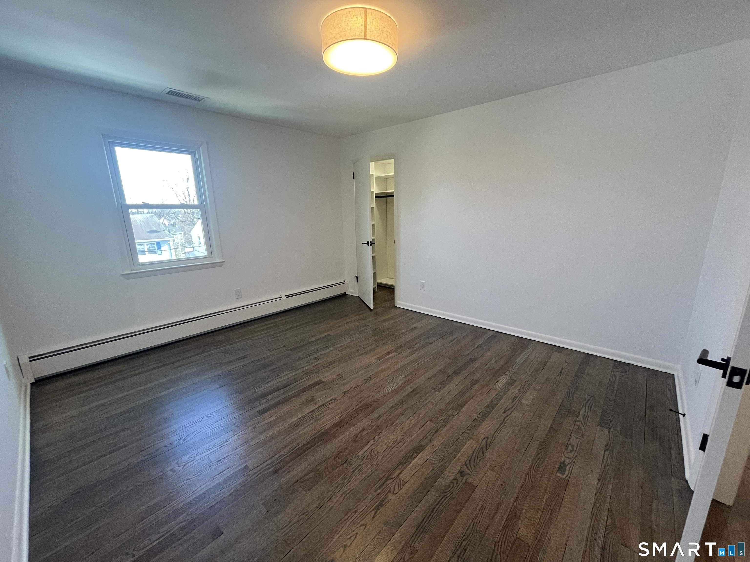 34 Keith Street, Unit 2 Stamford, CT 06902 - Photo 12 of 15 an empty room with wooden floor and windows