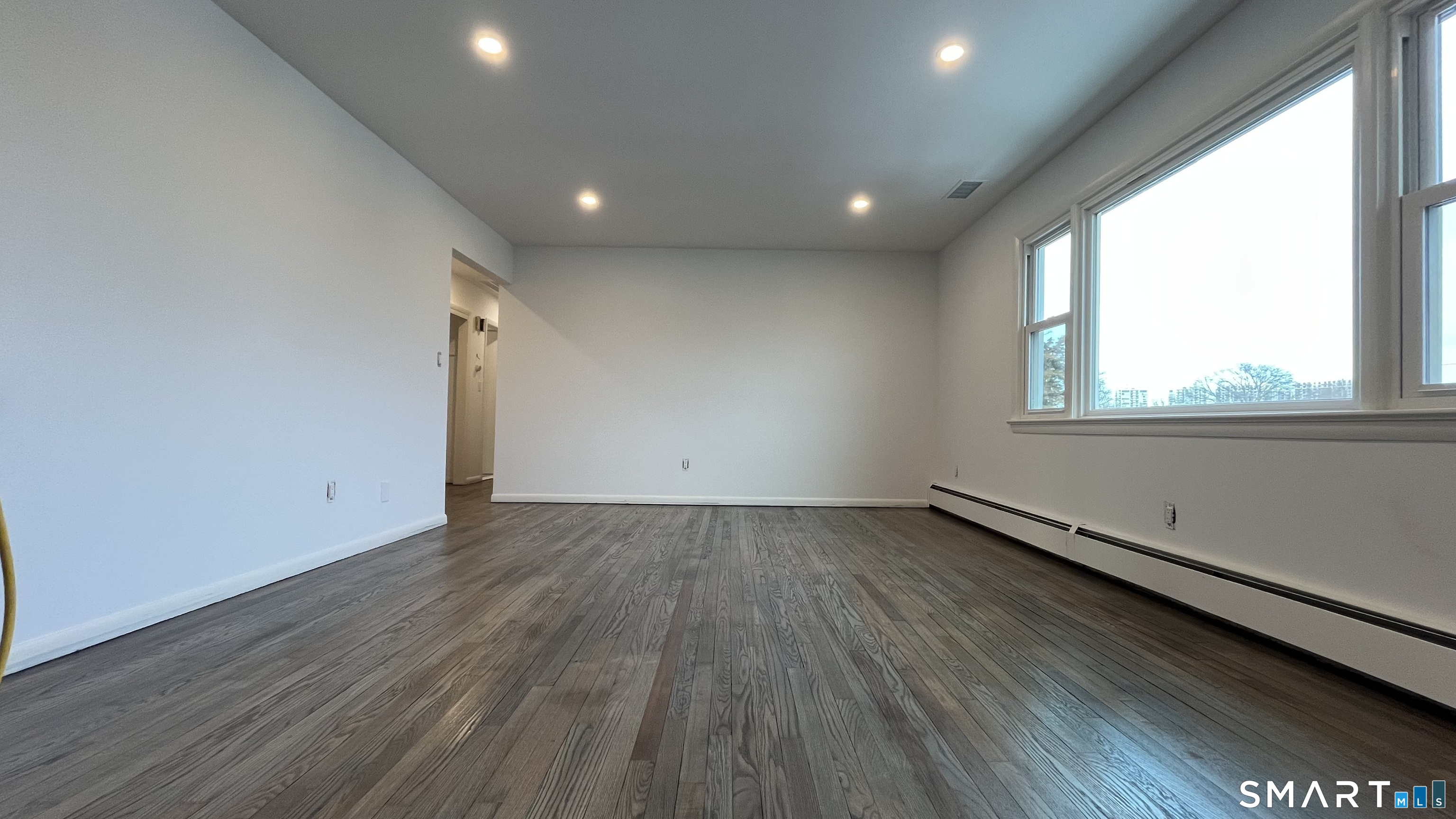 34 Keith Street, Unit 2 Stamford, CT 06902 - Photo 6 of 15 an empty room with wooden floor and windows