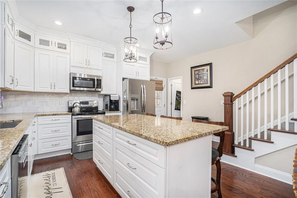 85 Jane Harris Road Dallas, GA 30157 - Photo 11 of 33 a kitchen with stainless steel appliances granite countertop a sink dishwasher and a stove with wooden floor
