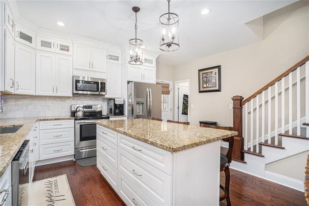 85 Jane Harris Road Dallas, GA 30157 - Photo 11 of 33 a kitchen with stainless steel appliances granite countertop a sink dishwasher and a stove with wooden floor