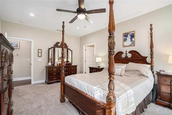 a bedroom with a bed a dresser and potted plants