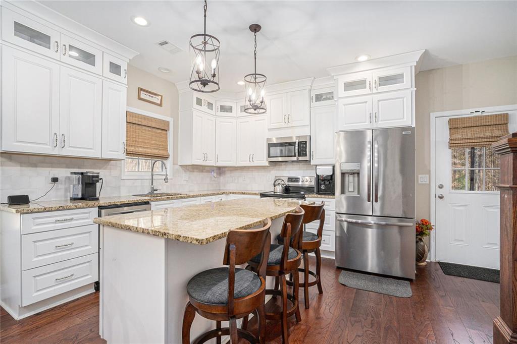 85 Jane Harris Road Dallas, GA 30157 - Photo 9 of 33 a kitchen with stainless steel appliances granite countertop a refrigerator a sink dishwasher a stove and white cabinets with wooden floor