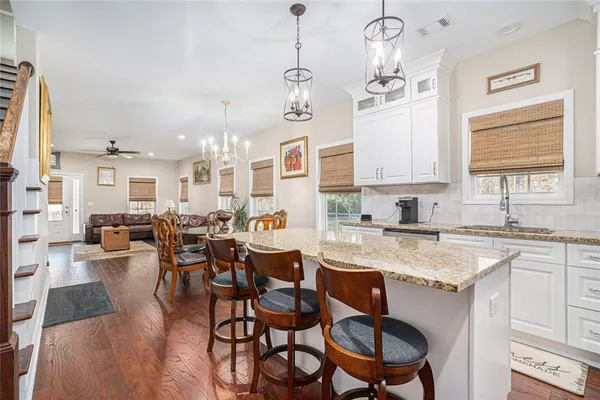 a kitchen with a dining table chairs sink and cabinets