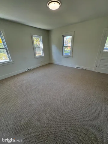 an empty room with windows and closet