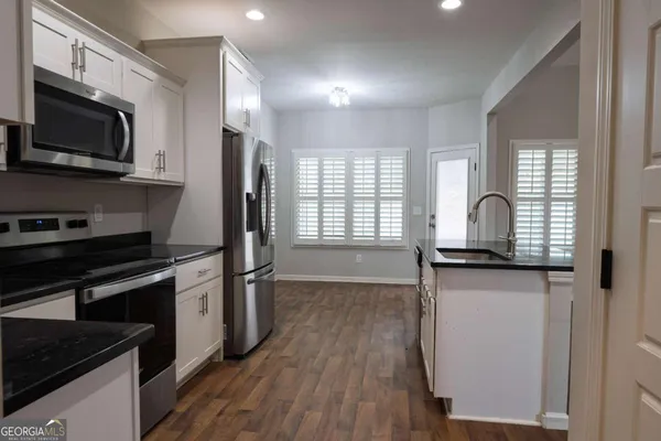 a kitchen with stainless steel appliances granite countertop a refrigerator a stove a sink and a microwave