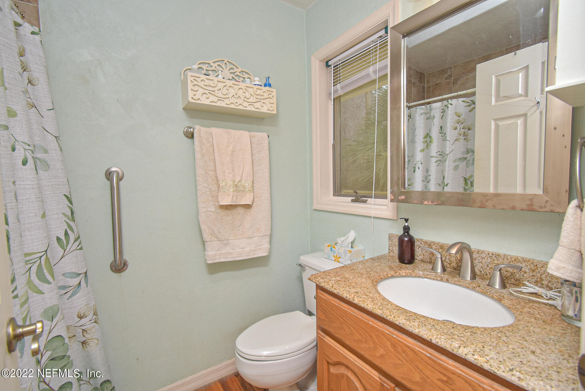 566 Clifton Road Crescent City, FL 32112 - Photo 26 of 41 a bathroom with a granite countertop sink toilet a mirror and shower