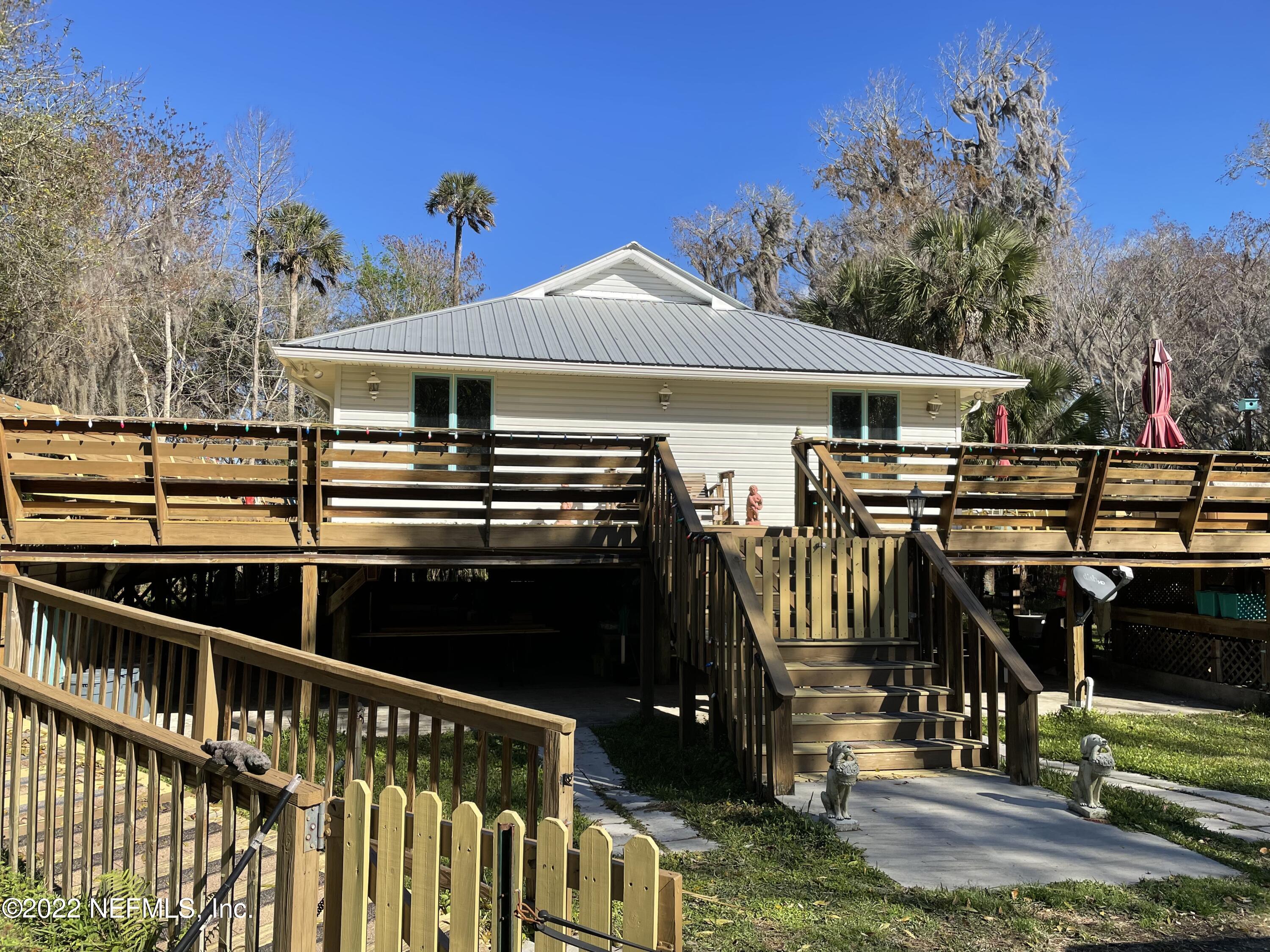 566 Clifton Road Crescent City, FL 32112 - Photo 40 of 41 a view of a patio with table and chairs a barbeque with wooden floor and fence
