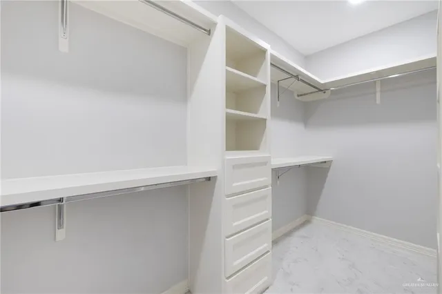 a view of walk in closet with empty racks