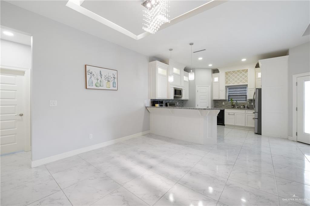 1422 South Esperanza Street Pharr, TX 78577 - Photo 4 of 16 a large white kitchen with kitchen island a sink stainless steel appliances and cabinets