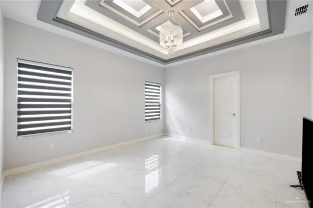 a view of a hallway with windows and chandelier