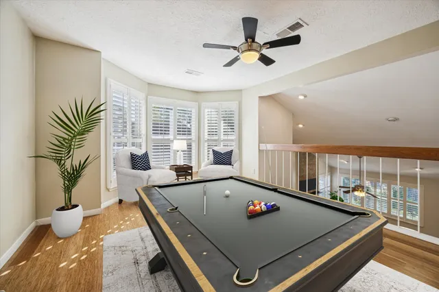 a living room with pool table and a large window