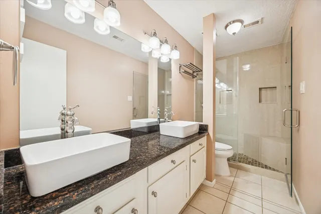 a spacious bathroom with a granite countertop sink mirror and a shower