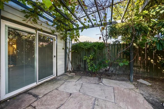 a view of backyard with large tree and wooden fence
