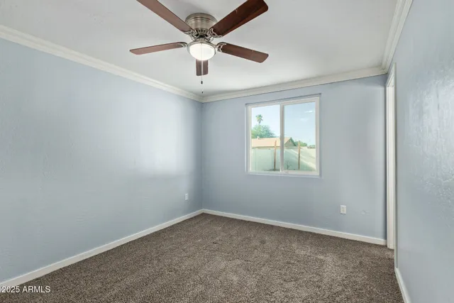 an empty room with a window and a fan