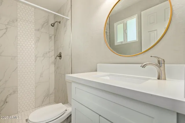 a bathroom with a sink a toilet and a mirror