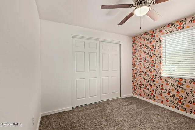 an empty room with a ceiling fan and a window