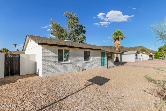 a front view of a house with a yard and potted plants