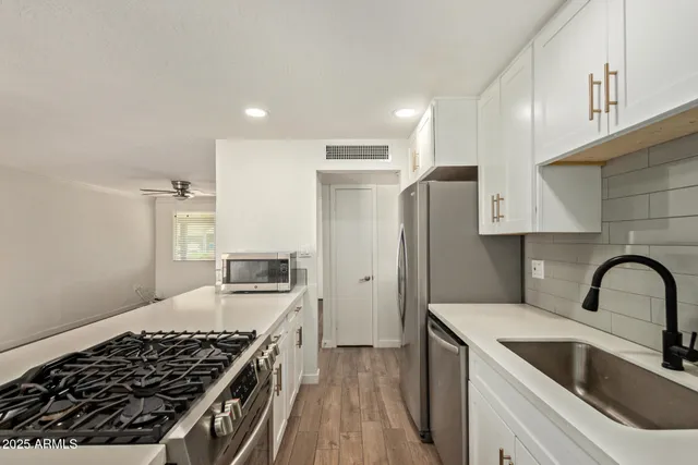 a kitchen with stainless steel appliances granite countertop a sink stove and refrigerator