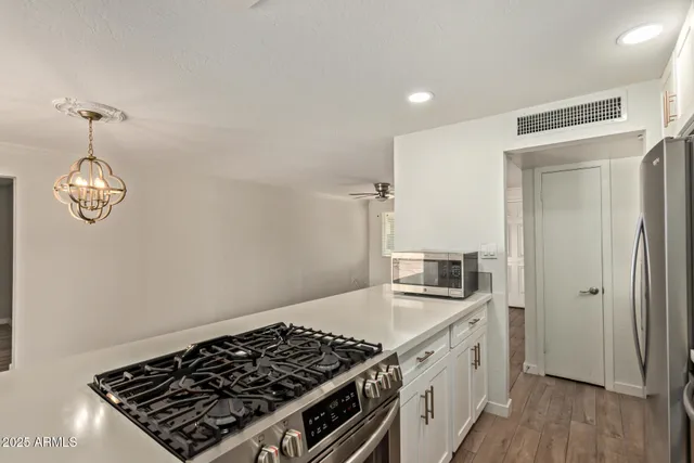 a kitchen with stainless steel appliances granite countertop a stove and a refrigerator