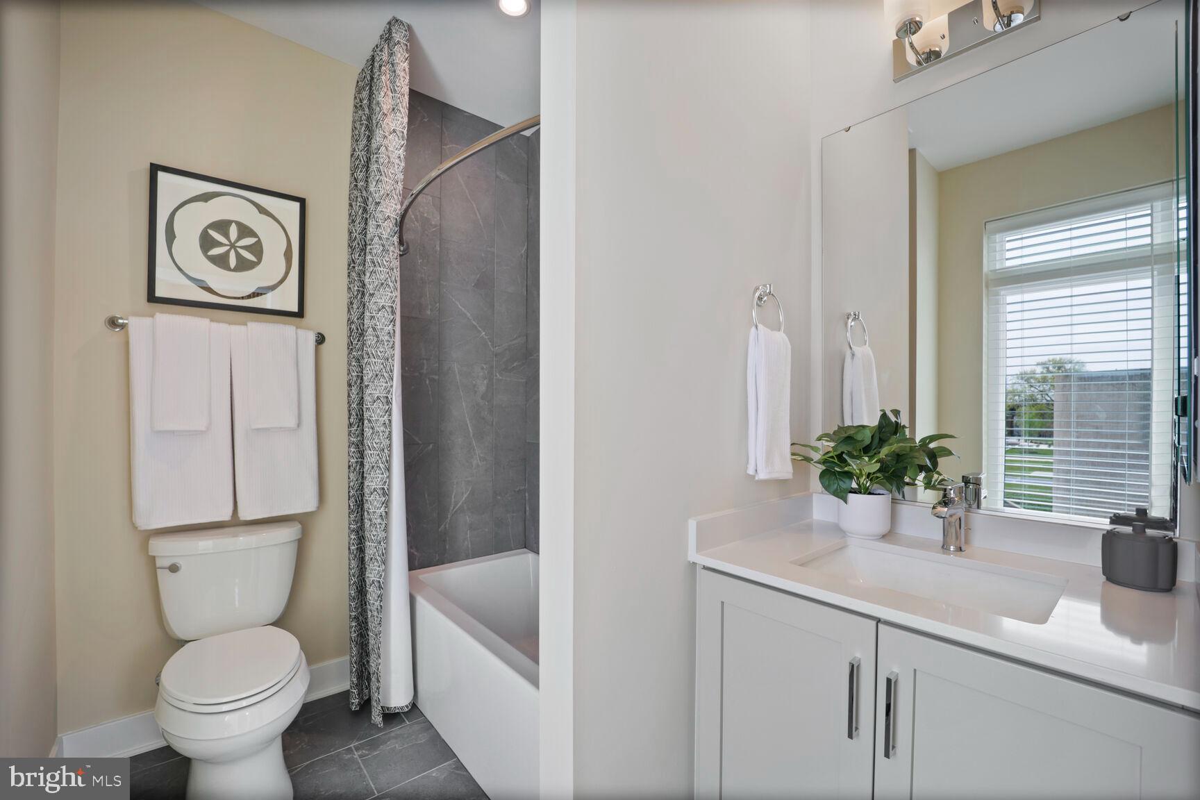 61 Lower Service Road Northwest, Unit HOMESITE 908 Washington, DC 20422 - Photo 20 of 22 a bathroom with a toilet sink and mirror