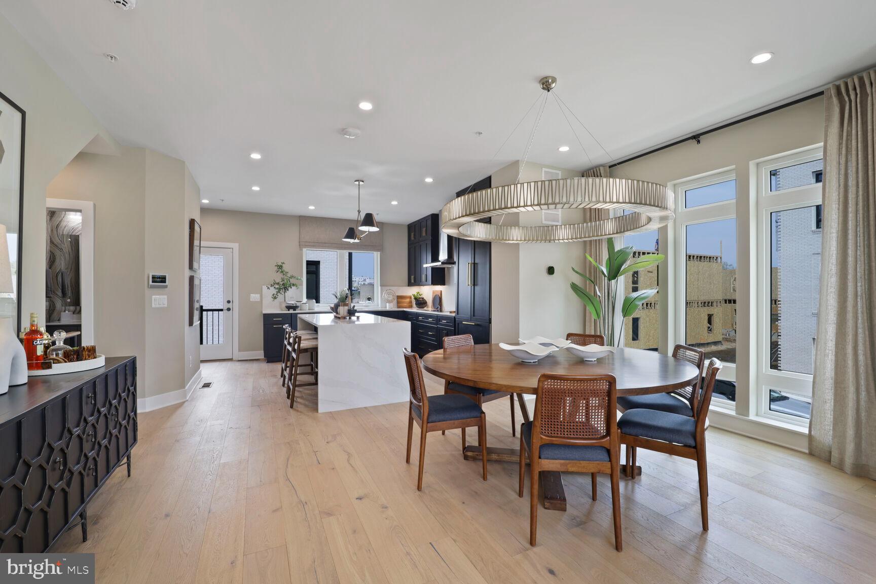 61 Lower Service Road Northwest, Unit HOMESITE 908 Washington, DC 20422 - Photo 7 of 22 a dining hall with stainless steel appliances a dining table and chairs with wooden floor