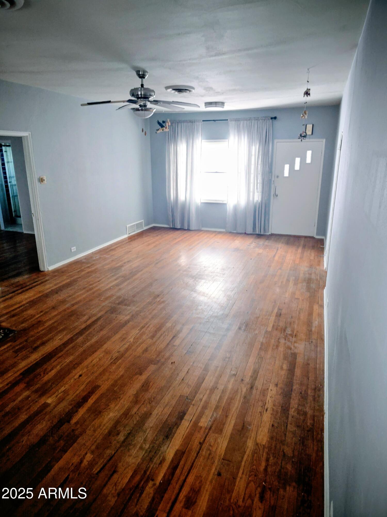 110 Arizona Street Bisbee, AZ 85603 - Photo 9 of 25 wooden floor in an empty room with a window