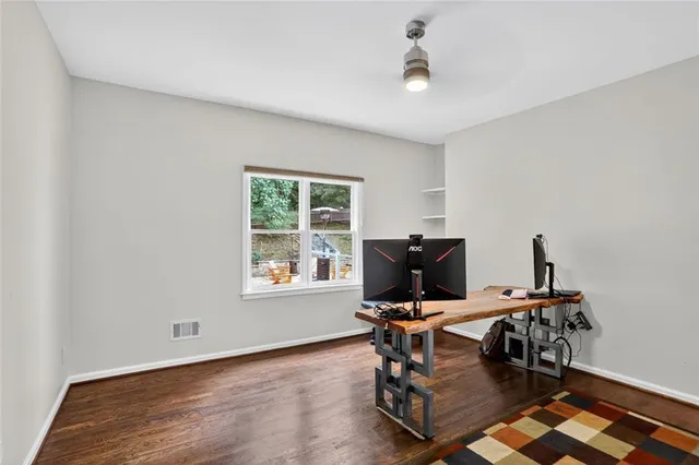 an empty room with wooden floor and windows