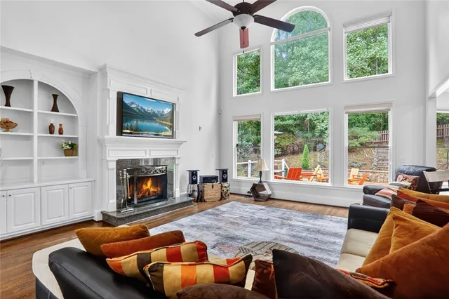 a dining room with wooden floor a chandelier a glass table and chairs