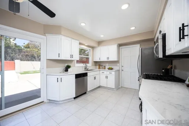 a kitchen with white cabinets and white appliances