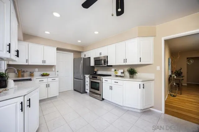 a kitchen with granite countertop white cabinets and white appliances
