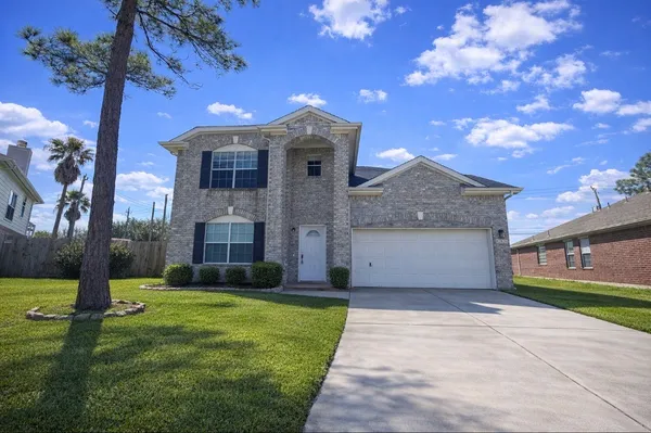 a view of a house with a big yard and large tree
