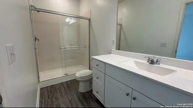 a bathroom with a sink a toilet and shower