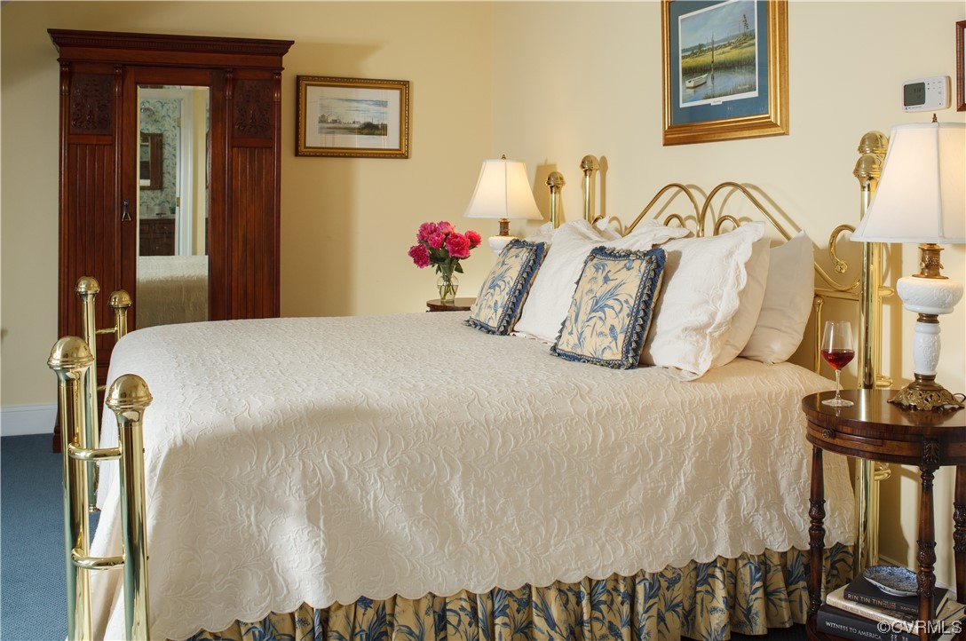 4750 Warner Hall Road Gloucester, VA 23061 - Photo 29 of 49 a bedroom with a bed and dresser with wooden floor