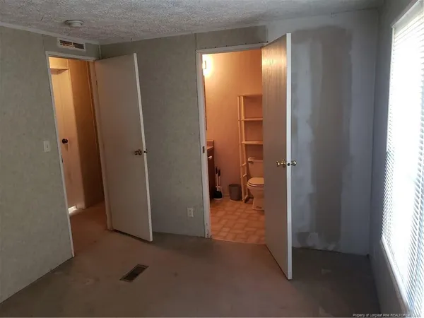 a room with a bed and dresser