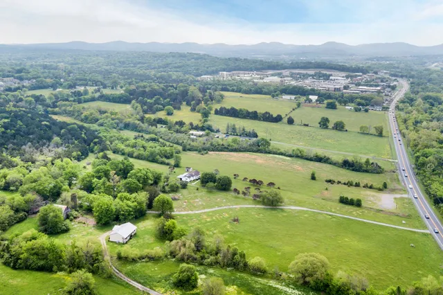 an aerial view of a residential houses with outdoor space and green view