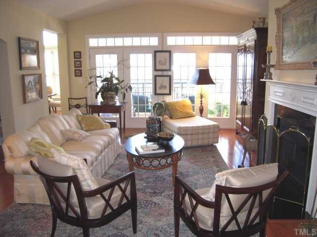 3700 Baron Cooper Pass, Unit 201 Raleigh, NC 27612 - Photo 3 of 12 There is a Gas Log Fireplace With a Black Marble Surround and a French Door Which Opens Onto the Covered Balcony Living Room