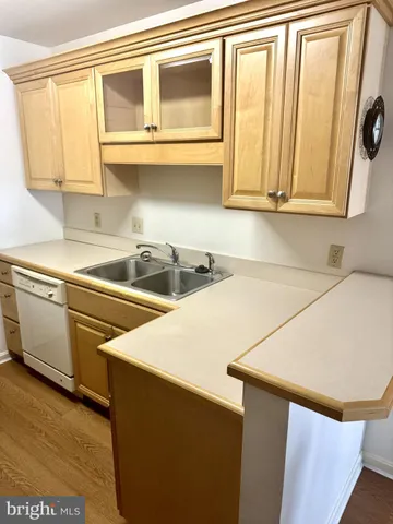 a kitchen with stainless steel appliances a refrigerator a sink and white cabinets
