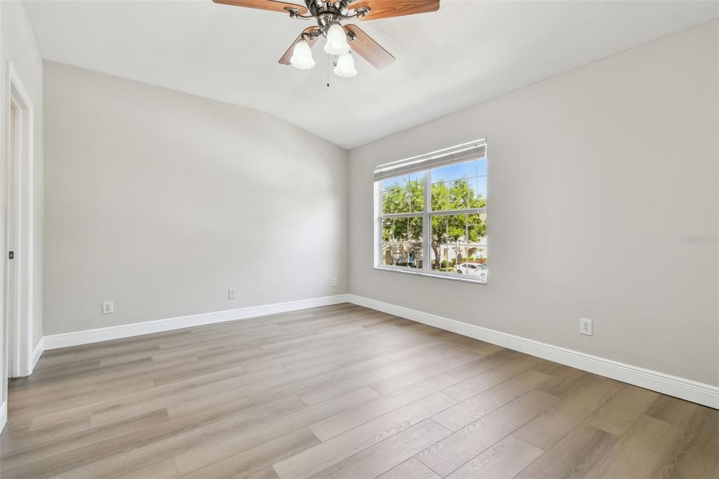 16227 Swan View Circle Odessa, FL 33556 - Photo 13 of 29 an empty room with wooden floor chandelier fan and windows