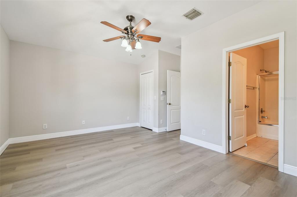 16227 Swan View Circle Odessa, FL 33556 - Photo 15 of 29 a view of an empty room with wooden floor and a ceiling fan