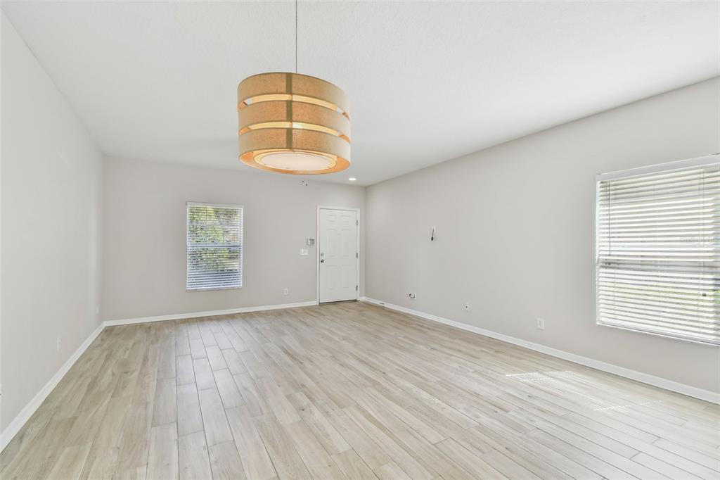 16227 Swan View Circle Odessa, FL 33556 - Photo 5 of 29 an empty room with wooden floor exposed radiator and windows