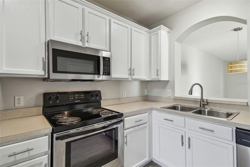 16227 Swan View Circle Odessa, FL 33556 - Photo 8 of 29 a kitchen with stainless steel appliances granite countertop grey cabinets a stove a sink and dishwasher