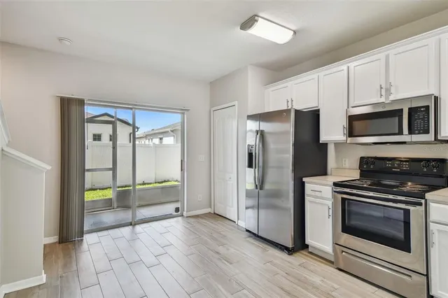 a large kitchen with a lot of counter space and stainless steel appliances