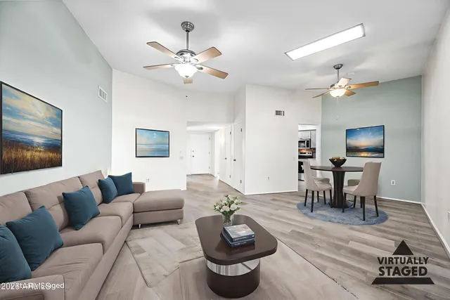 a living room with furniture a dining table and a chandelier