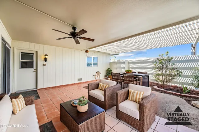 a living room with furniture a rug potted plant and a window